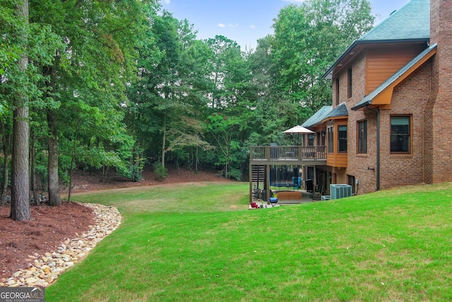 view of yard with a wooden deck and central air condition unit