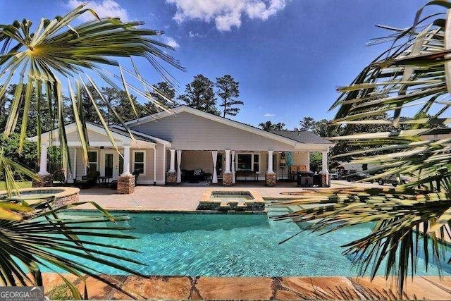 view of pool with a pool with connected hot tub and a patio