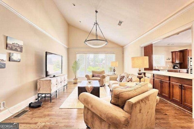 living room featuring light wood-type flooring, vaulted ceiling, and ornamental molding