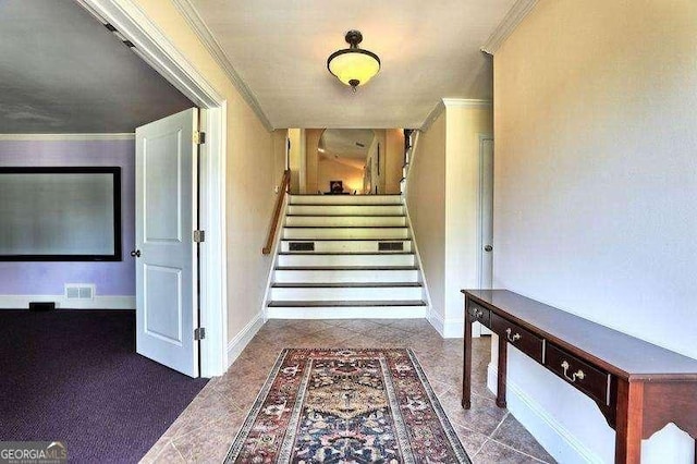 stairs with baseboards, visible vents, and ornamental molding