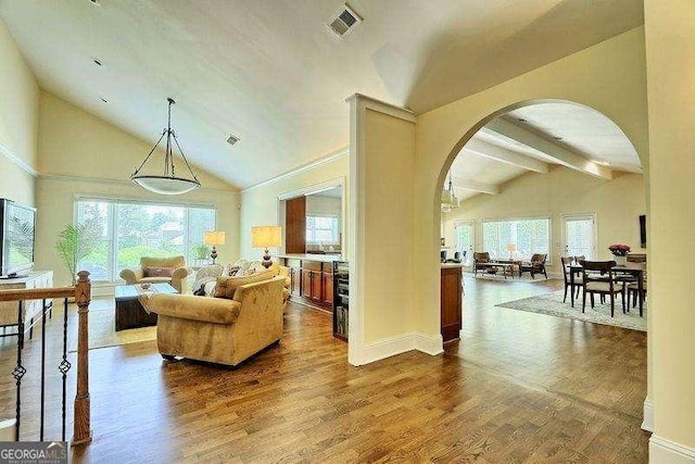 living room featuring hardwood / wood-style flooring, high vaulted ceiling, and beamed ceiling