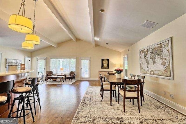 dining area featuring dark wood-type flooring and lofted ceiling with beams