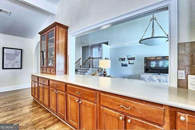 kitchen featuring light hardwood / wood-style floors and vaulted ceiling with beams