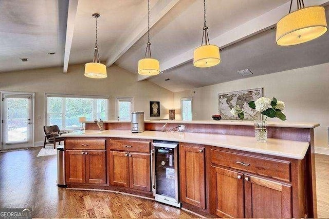 kitchen featuring beverage cooler, a center island, decorative light fixtures, vaulted ceiling with beams, and light hardwood / wood-style floors