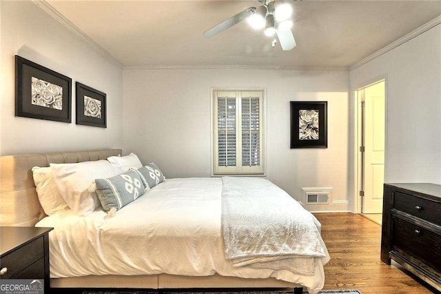 bedroom with light wood-type flooring, ceiling fan, and ornamental molding