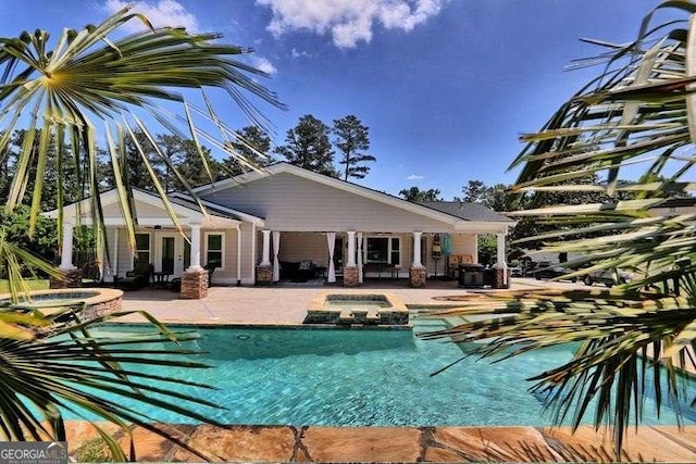 view of swimming pool featuring a patio area and an in ground hot tub