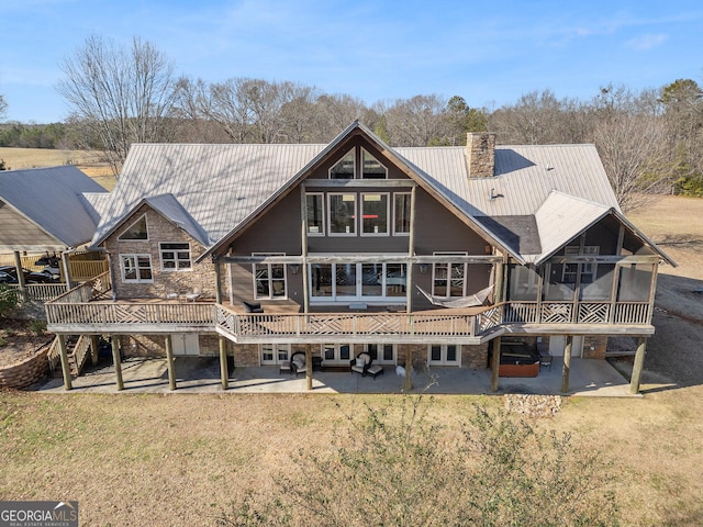 rear view of property with a lawn, a deck, and a patio