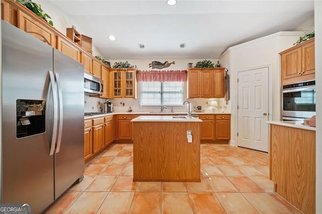 kitchen featuring sink, light tile patterned floors, a center island with sink, and stainless steel appliances