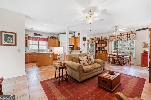 tiled living room with ceiling fan and a healthy amount of sunlight