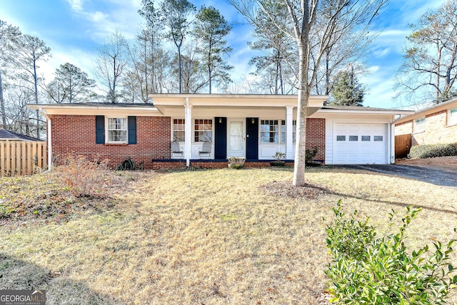 single story home with a porch, a garage, and a front yard