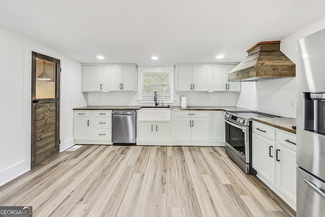 kitchen featuring white cabinetry, stainless steel appliances, and custom exhaust hood