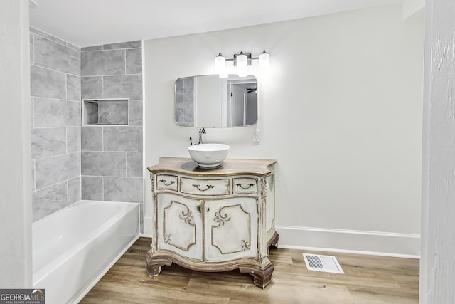 bathroom with hardwood / wood-style floors, vanity, and shower / bathing tub combination