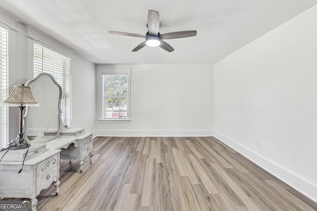 unfurnished office with ceiling fan and light wood-type flooring