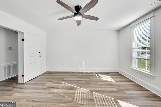 spare room featuring ceiling fan, a wealth of natural light, and light hardwood / wood-style floors