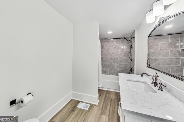 bathroom featuring hardwood / wood-style floors, vanity, and shower / tub combo