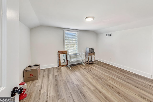 living area with light wood-type flooring and vaulted ceiling