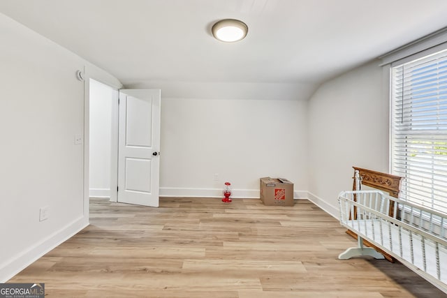 unfurnished room featuring vaulted ceiling and light hardwood / wood-style flooring