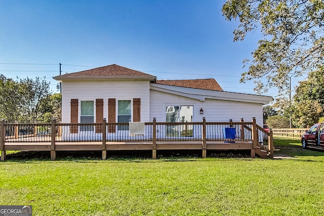 back of property with a wooden deck and a yard