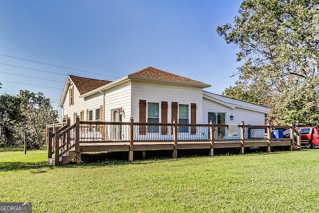 rear view of property with a deck and a lawn