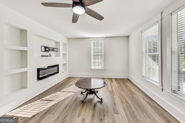 living room featuring ceiling fan, built in shelves, and hardwood / wood-style flooring