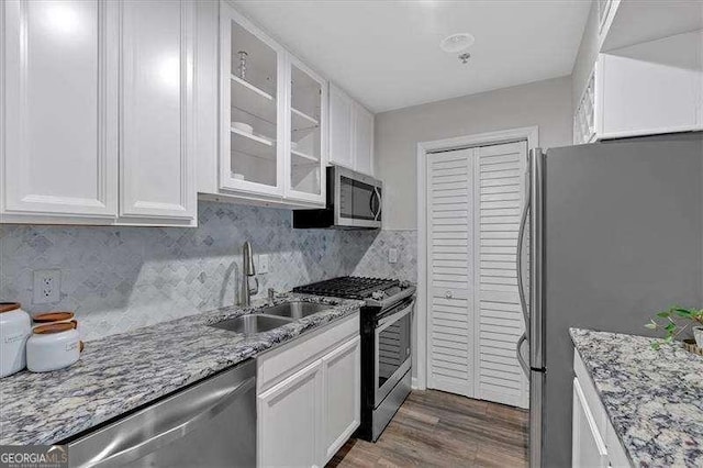 kitchen featuring light stone counters, sink, white cabinets, and appliances with stainless steel finishes