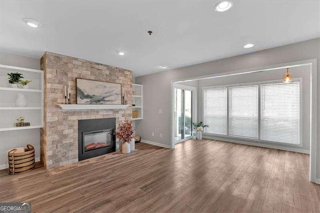 living room featuring wood-type flooring and a large fireplace