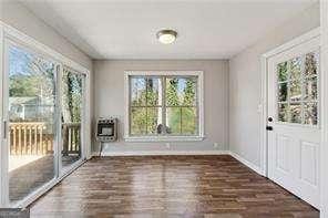 entryway with dark wood-type flooring, heating unit, and a healthy amount of sunlight