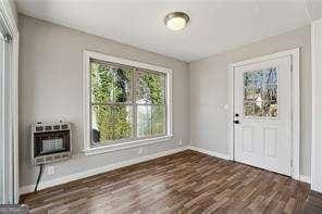 unfurnished dining area with heating unit and dark hardwood / wood-style floors