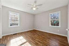 empty room with ceiling fan and dark hardwood / wood-style floors