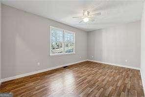 empty room featuring ceiling fan and dark hardwood / wood-style floors