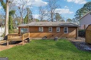 back of house featuring a wooden deck and a lawn