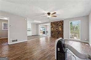 unfurnished living room with ceiling fan and dark hardwood / wood-style flooring