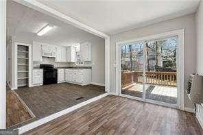 interior space with stove, dark hardwood / wood-style flooring, and white cabinetry