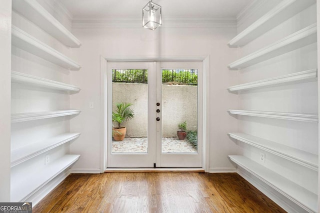 entryway with dark hardwood / wood-style flooring, crown molding, and french doors