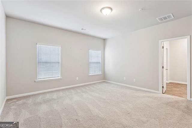 spare room featuring light colored carpet