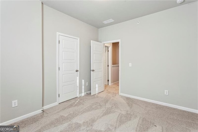 unfurnished bedroom featuring light carpet