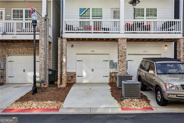 view of front of house with a garage and central air condition unit