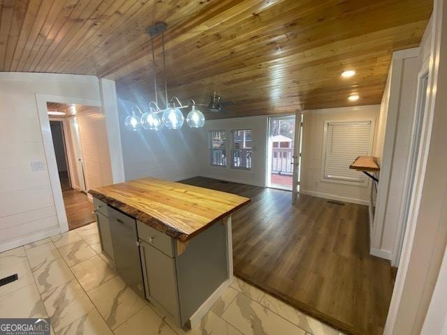 kitchen featuring wood ceiling, hanging light fixtures, a center island, and butcher block counters