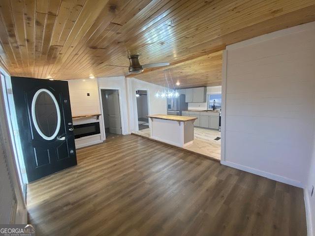 kitchen featuring wood-type flooring, butcher block countertops, a kitchen island, white cabinetry, and stainless steel fridge with ice dispenser