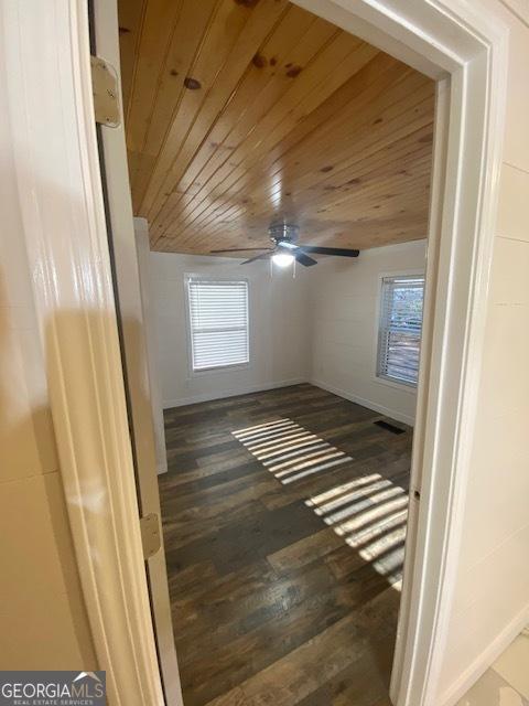 interior space featuring wood-type flooring, ceiling fan, and wooden ceiling
