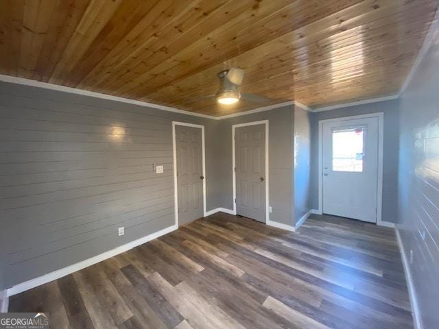 entryway with dark hardwood / wood-style flooring, crown molding, wooden walls, and wooden ceiling