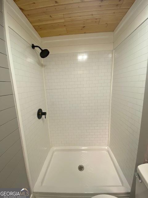 full bathroom featuring toilet, a shower stall, and wooden ceiling