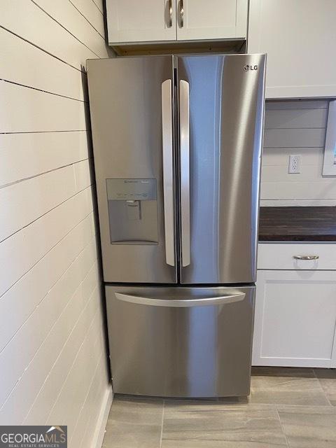 kitchen with stainless steel fridge with ice dispenser and white cabinets