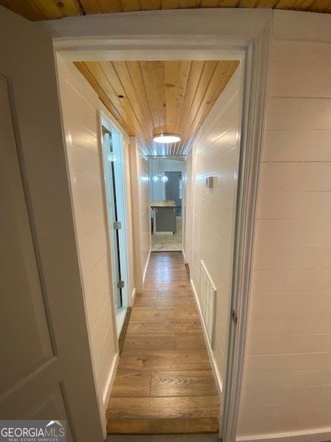 hallway with hardwood / wood-style flooring and wood ceiling