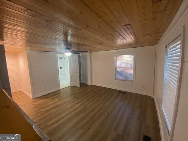 empty room with ceiling fan, wood ceiling, and dark hardwood / wood-style floors