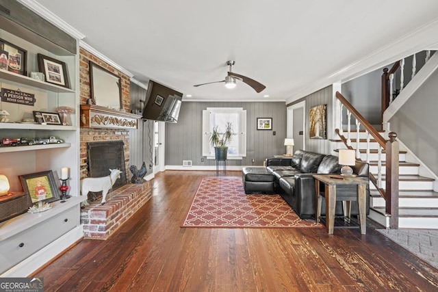 living room with ornamental molding, a brick fireplace, and dark hardwood / wood-style flooring