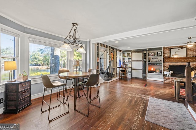 dining room featuring ceiling fan, crown molding, dark hardwood / wood-style floors, and built in shelves