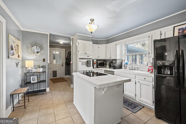 kitchen with sink, light tile patterned floors, black appliances, white cabinets, and tile countertops