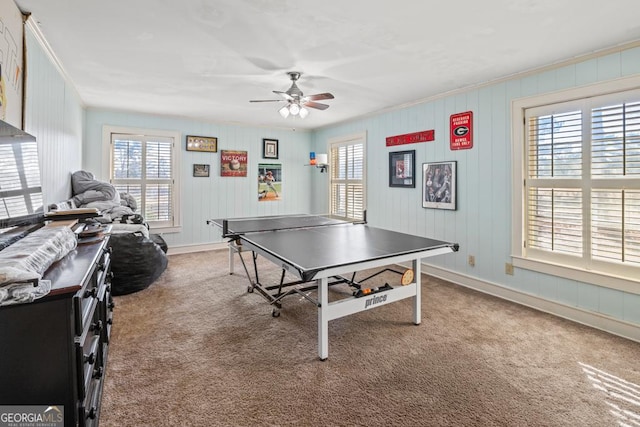 recreation room with crown molding, ceiling fan, and carpet floors