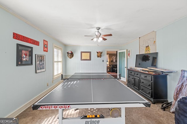 recreation room featuring ceiling fan, ornamental molding, and carpet floors